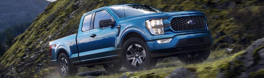 Ford F-150 driving up a gravel road.