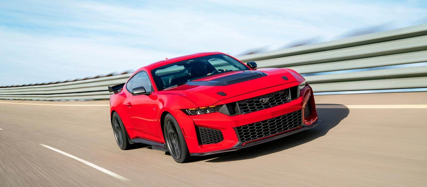 Red sports car on a curved highway, showcasing speed and modern design.
