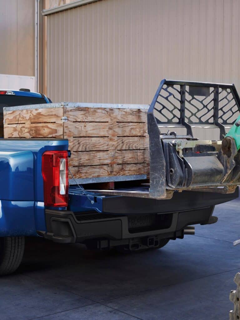 2027 Ford F-250 rear view of blue pickup bed with wooden crate and loader attachment