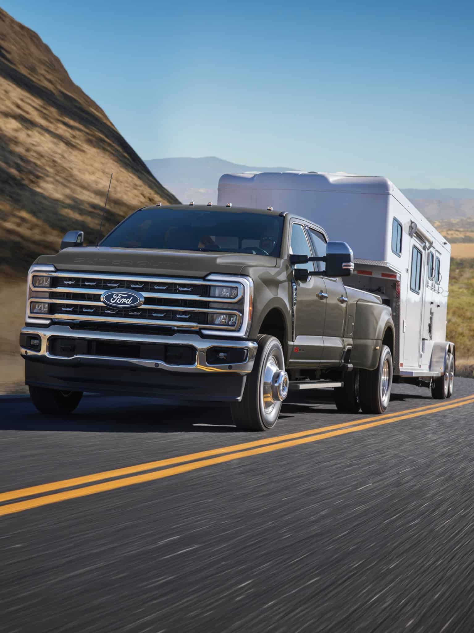 2027 Ford F-250 front view towing a horse trailer on a desert road