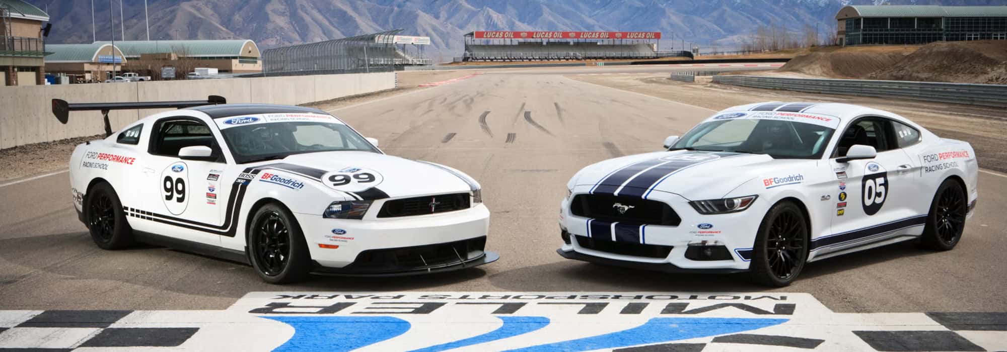 Two Ford Performance Mustangs at a racetrack, showcasing racing decals and numbers.