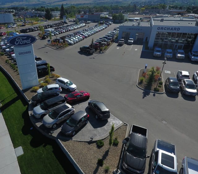 Aerial view of Orchard Ford dealership, displaying numerous parked cars and prominent signage.