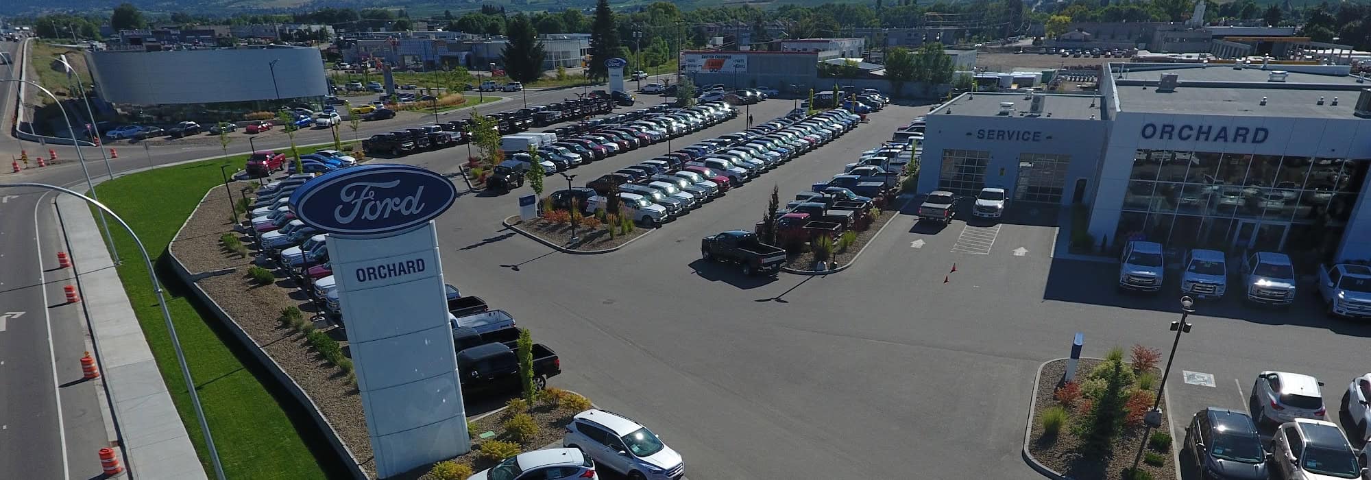 Aerial view of Orchard Ford dealership with parking lot full of cars and prominent Ford signage.